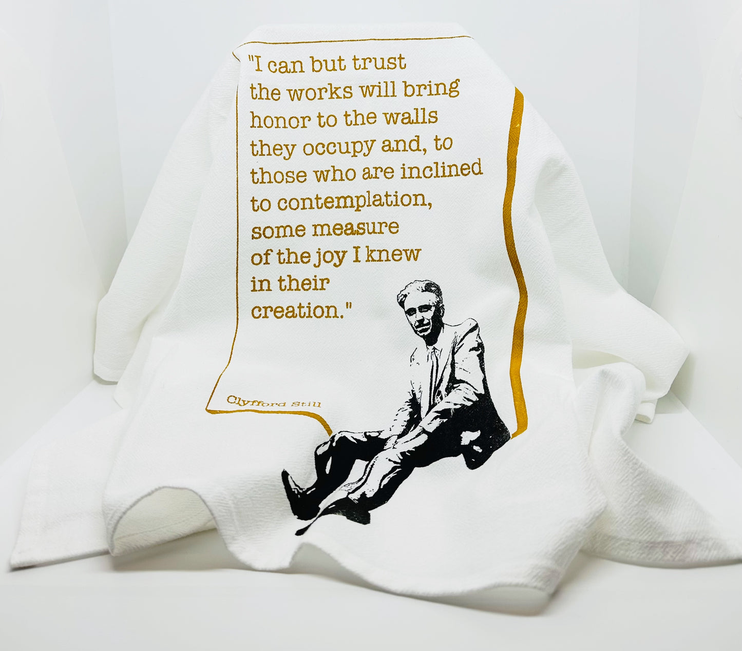 Quote Dish Towel. Black and White Image of Clyfford Still sitting on the gold boarder surrounding the quote.