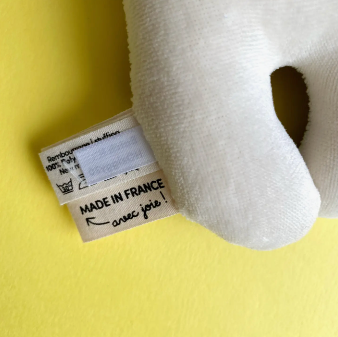 Close up of rattle tag text “Made in France, Avec joie!”