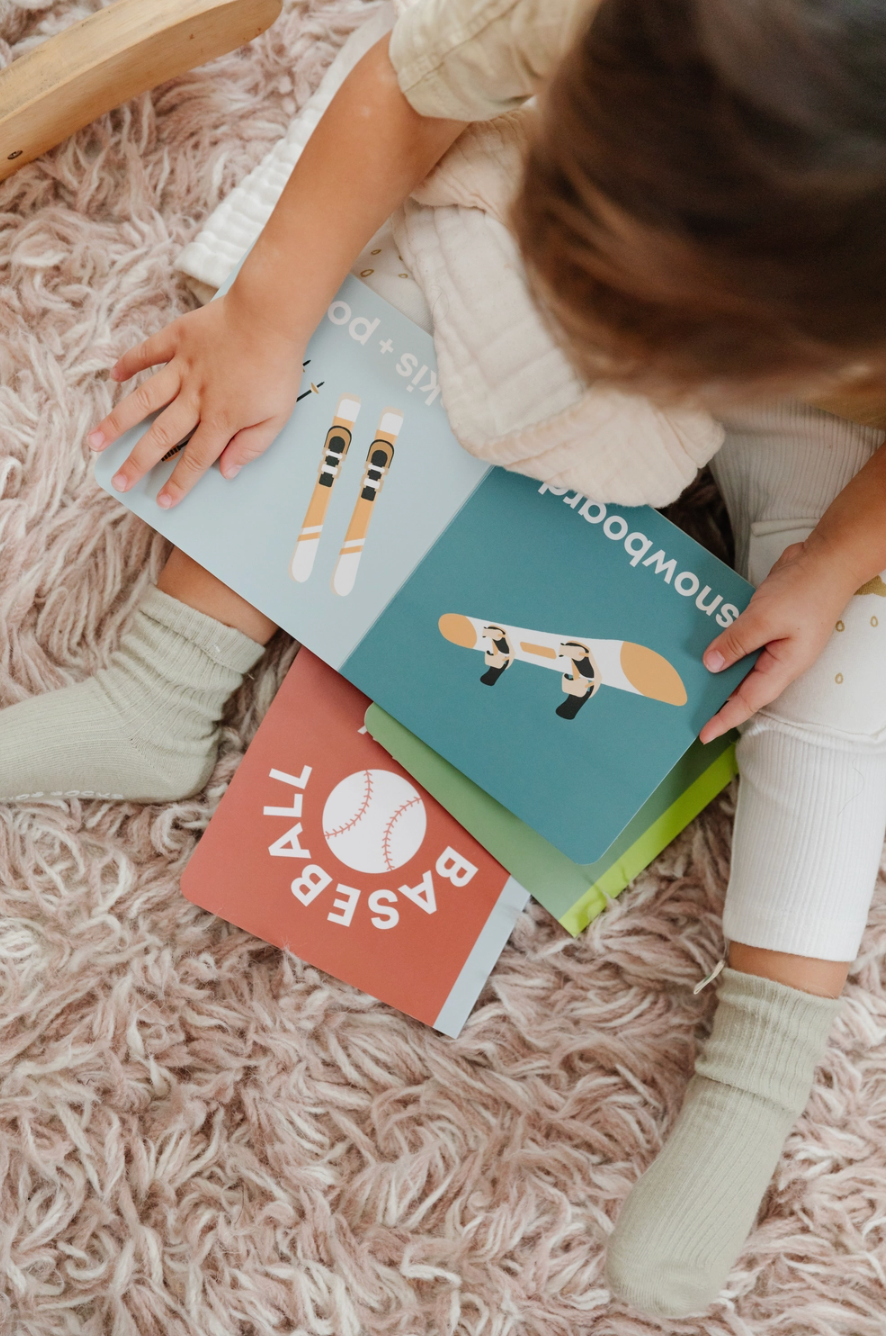 Top view of a toddler holding a square picture book