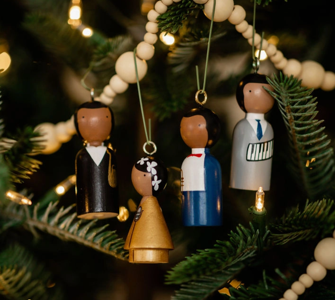 Decorative Christmas ornaments on a tree with lights and beads.