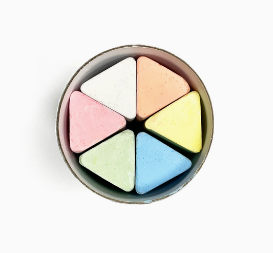 Round container with six pastel-colored watercolor crayons on a white background.