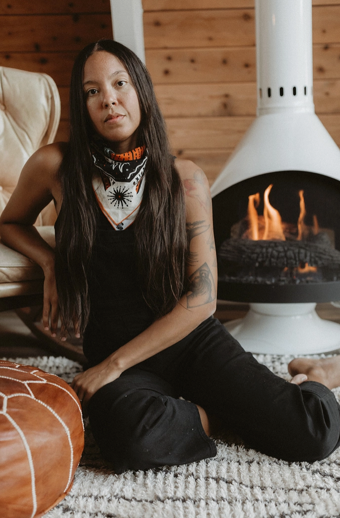Person sitting in front of a fireplace wearing a bandana