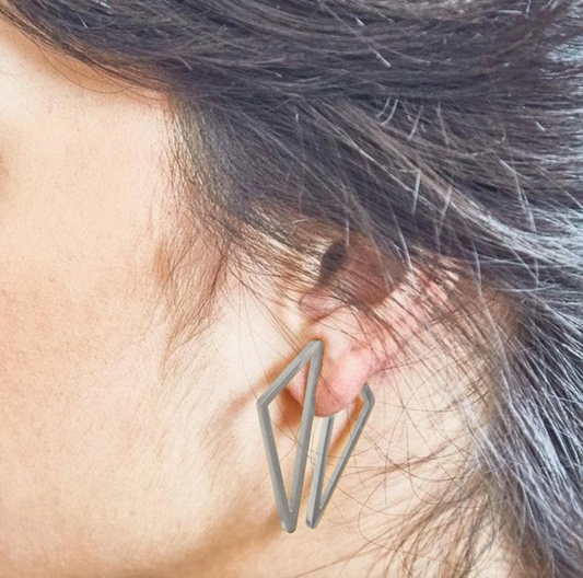 Silver geometric earring being worn