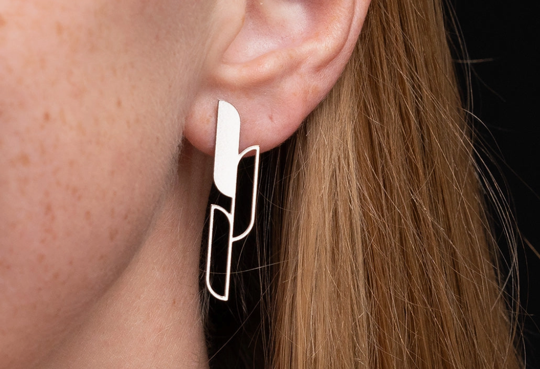 Close-up of a woman wearing a gold Ascend earring