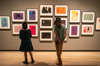 Photo of a couple viewing a gallery wall of Clyfford Still’s drawings