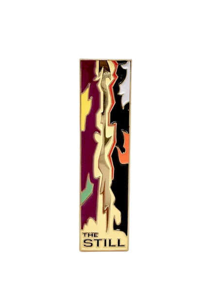 Decorative pin with abstract design and 'The Still' text on a white background
