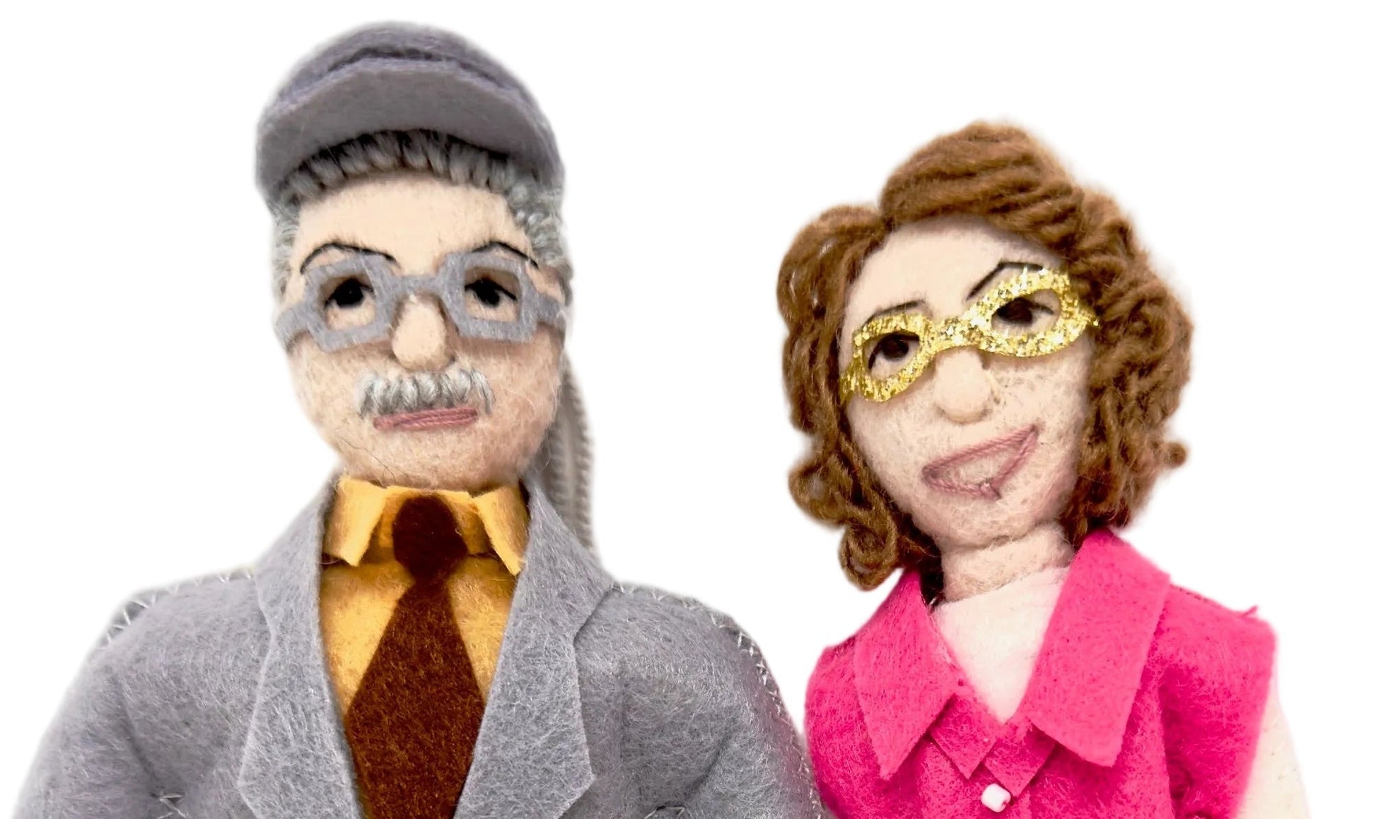 Two felt ornaments,  one in a gray coat and the other in a pink outfit, standing next to each other on a white background.