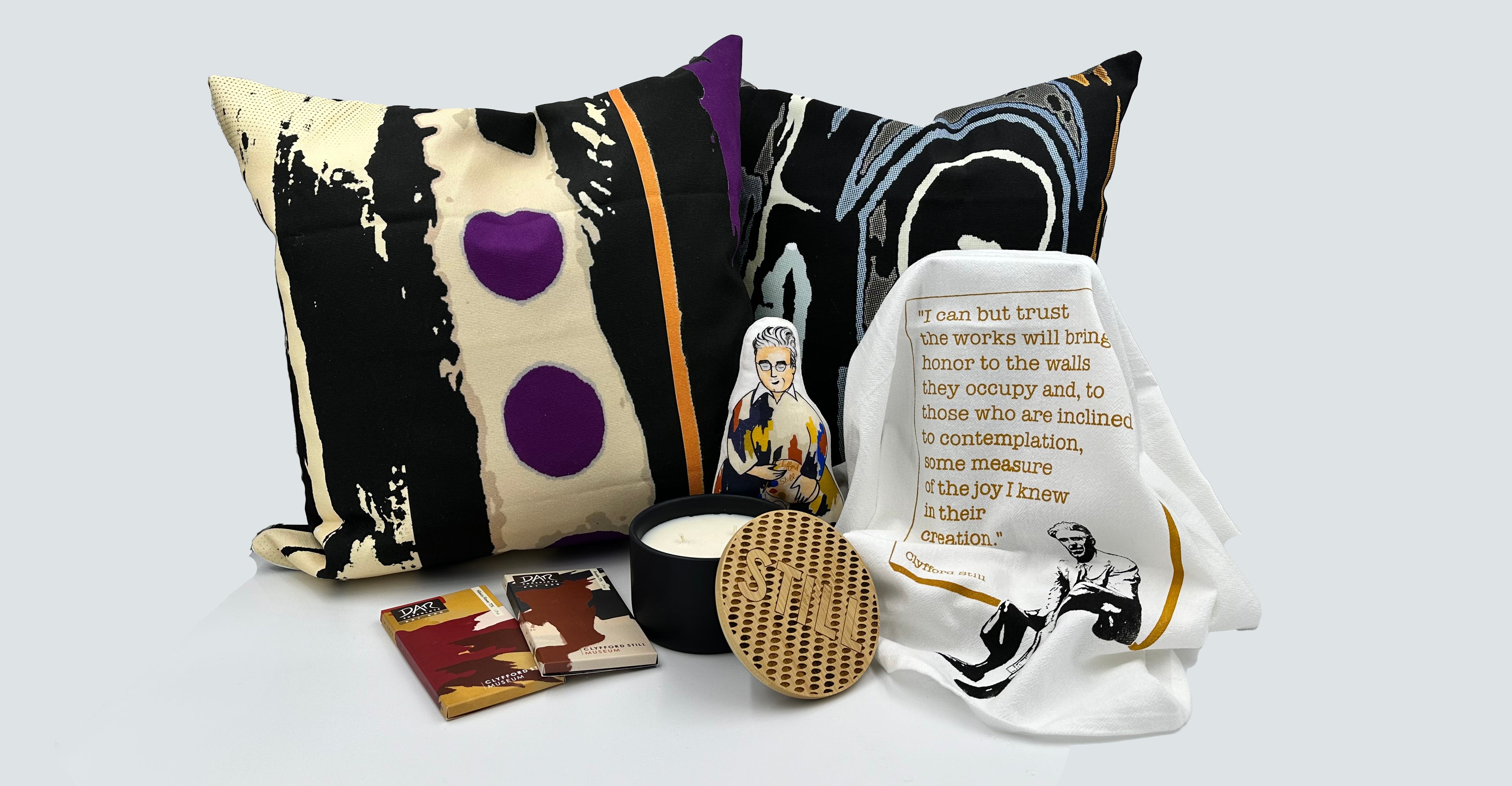 New in Shop items including decorative pillow, chocolate bars, candle, dishtowel, and rattle