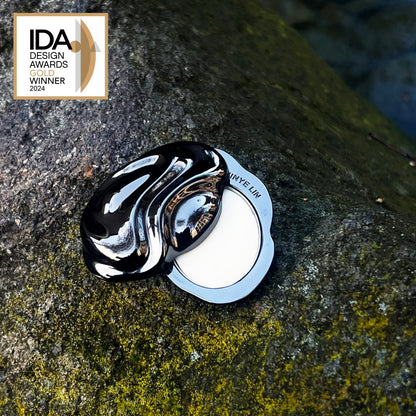 Black and white decorative object on a textured stone surface with IDA Design Awards 2024 Winner badge.