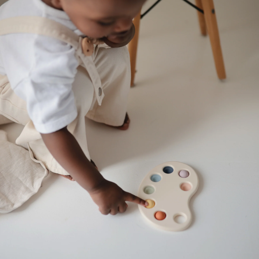 Child popping a color in the Paint Palette Press Toy