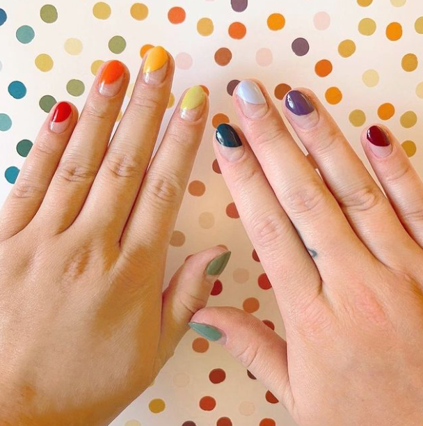 Two hands with rainbow finger nails 