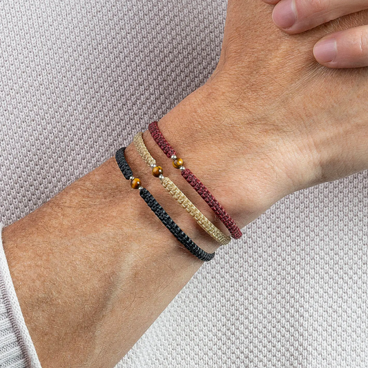 A mans wrist with three Macrame Bracelets.