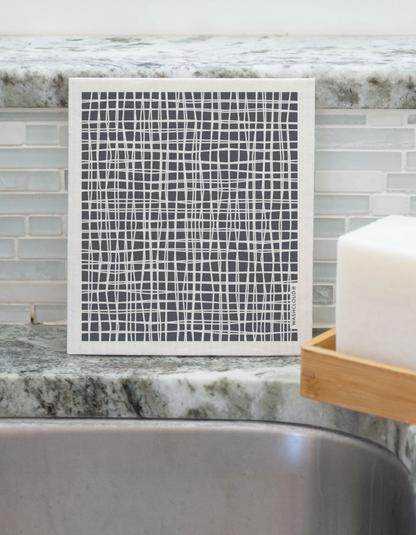 Reusable Square Paper Towel with gray pattern sitting on sink counter next to the Dish Block Soap.