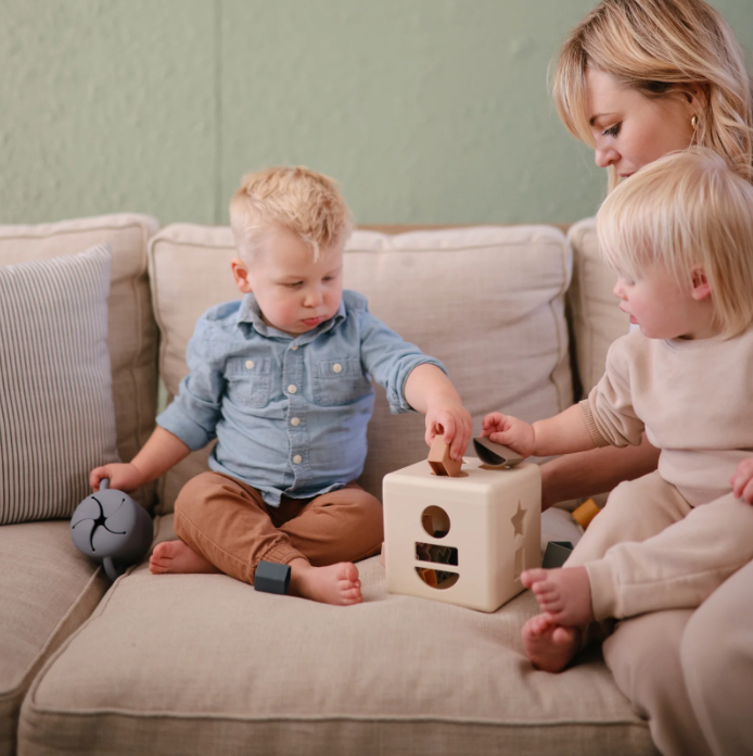 Woman and two children playing with the Shape Sorting Box