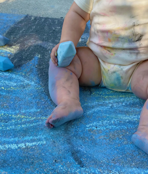 Image of young child with chalk dust on body.