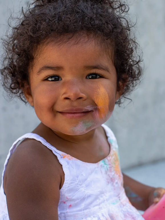 Image of young child with chalk dust on face.