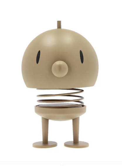 Beige Hoptimist Speaker with a round body and legs on a white background
