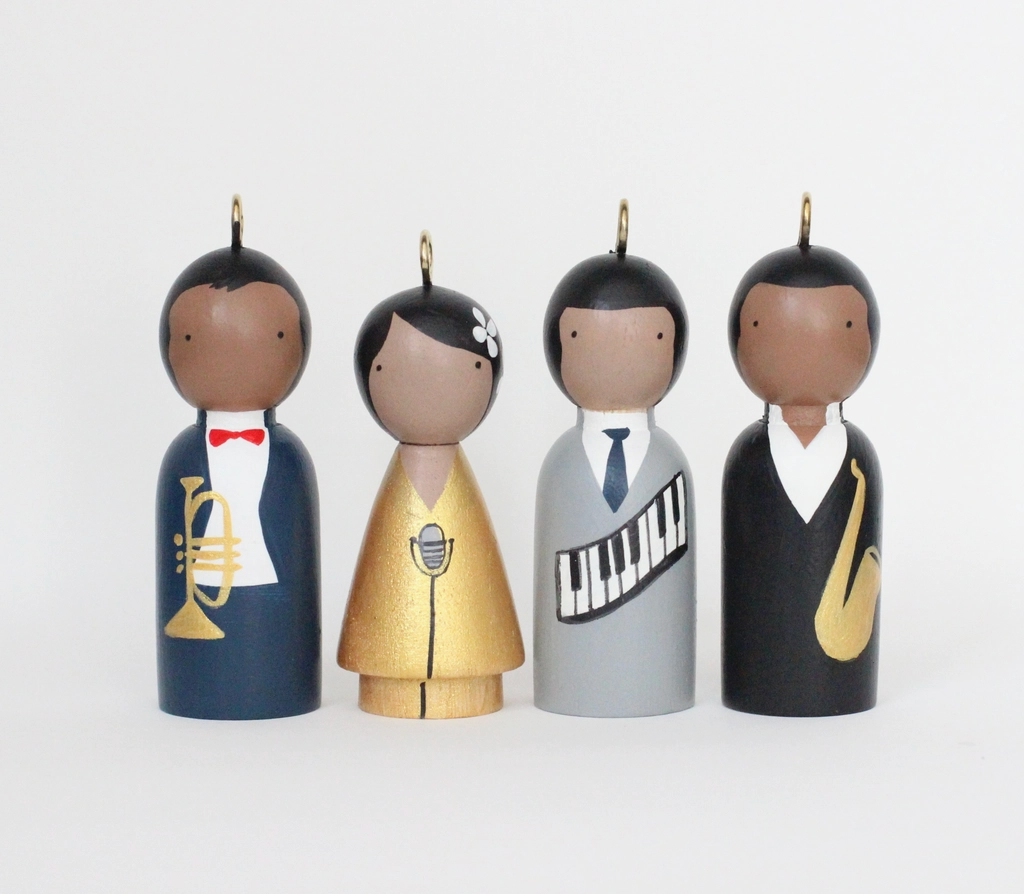 Four wooden Jazz figurines with musical instruments on a white background.