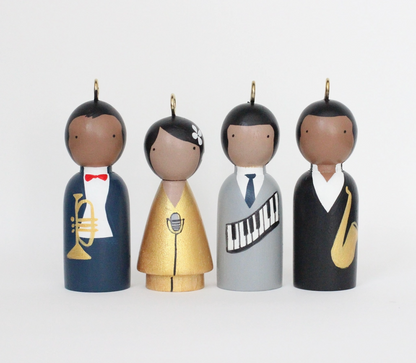 Four wooden Jazz figurines with musical instruments on a white background.