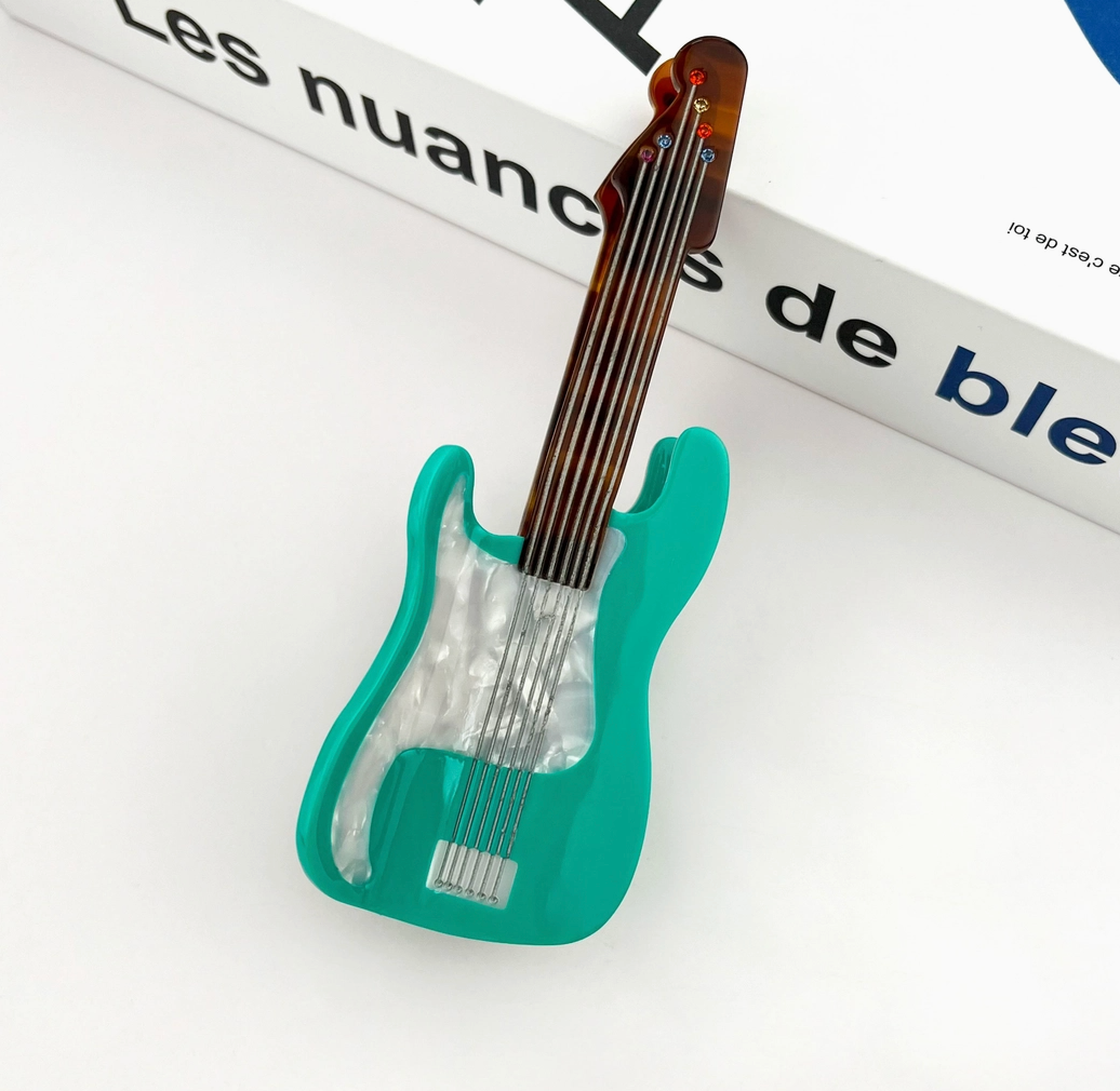 Teal guitar-shaped object on a white surface with text in the background