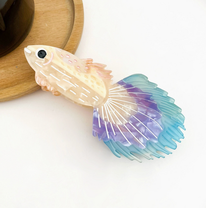 Decorative fish-shaped hair clip with gradient colors on a white background.