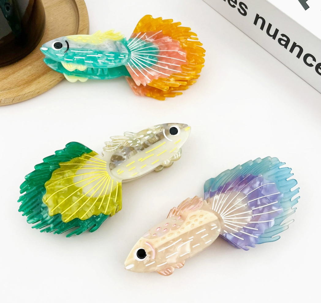 Colorful fish-shaped hair clips on a white surface.