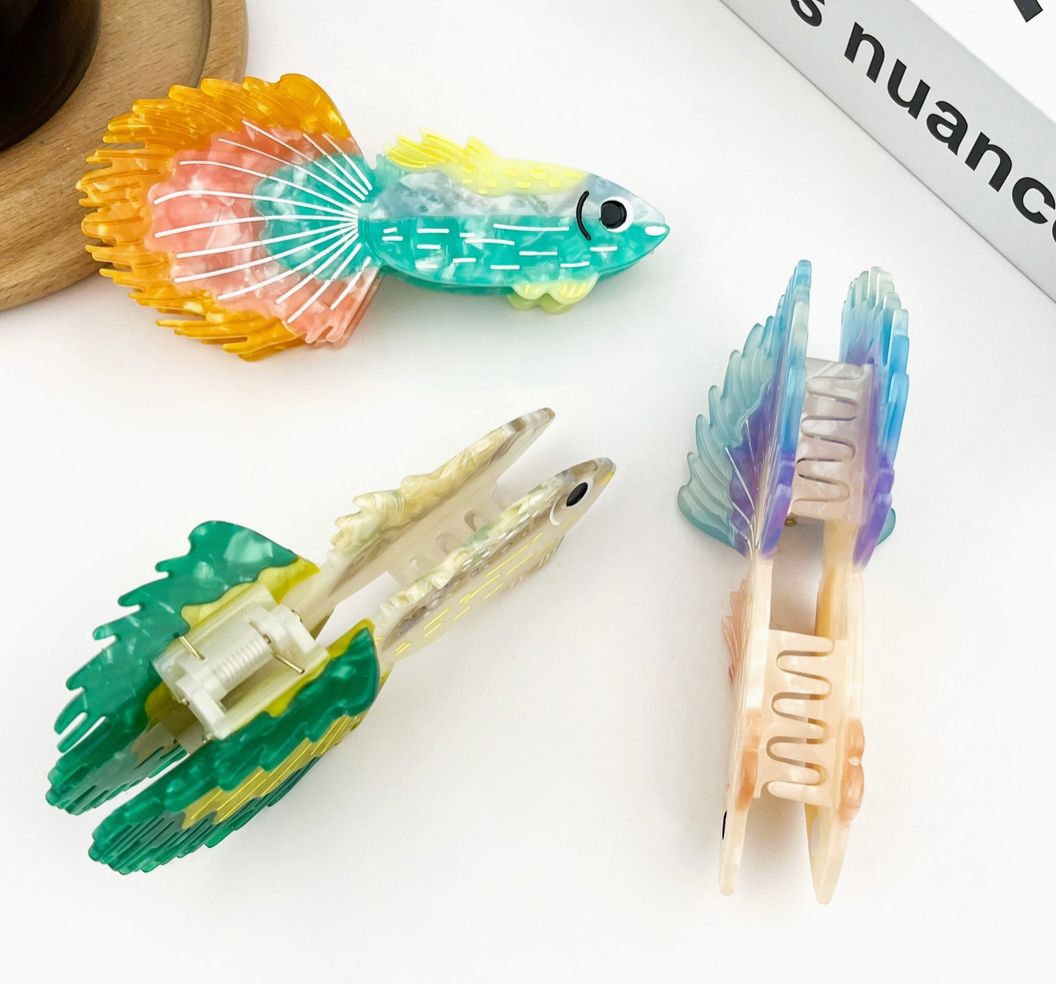 Colorful fish-shaped clips on a white surface.