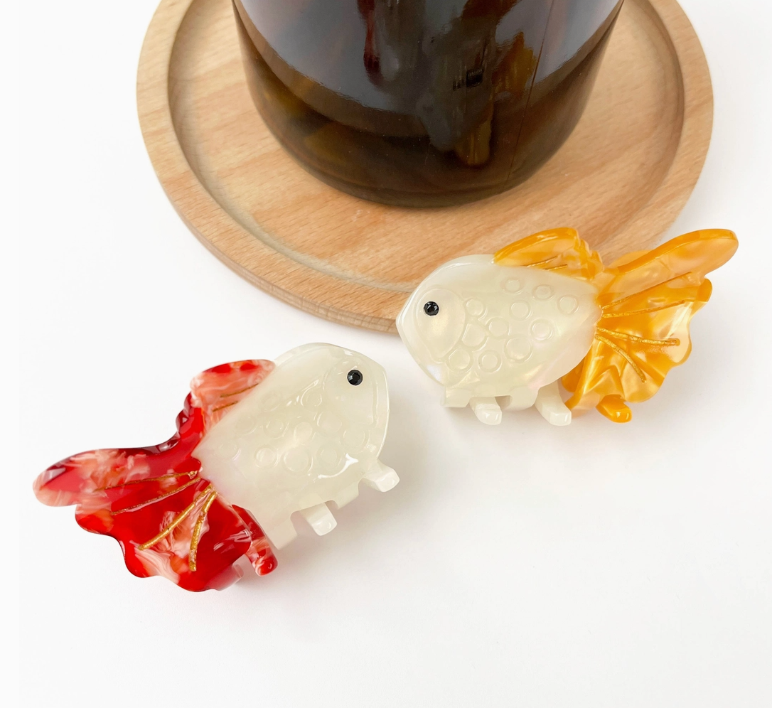 Two goldfish-shaped hair clips on a white background.