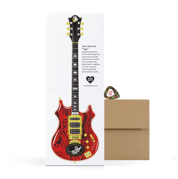 Greeting card with a red electric guitar design, envelope, and pick on a white background