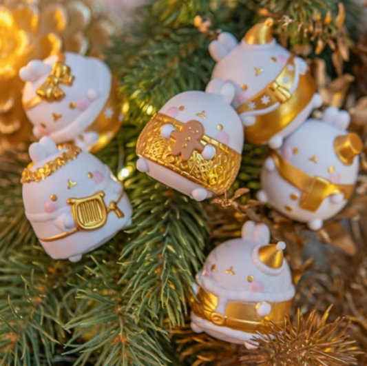 Decorative Christmas ornaments shaped like bunnies with gold accents on a tree.