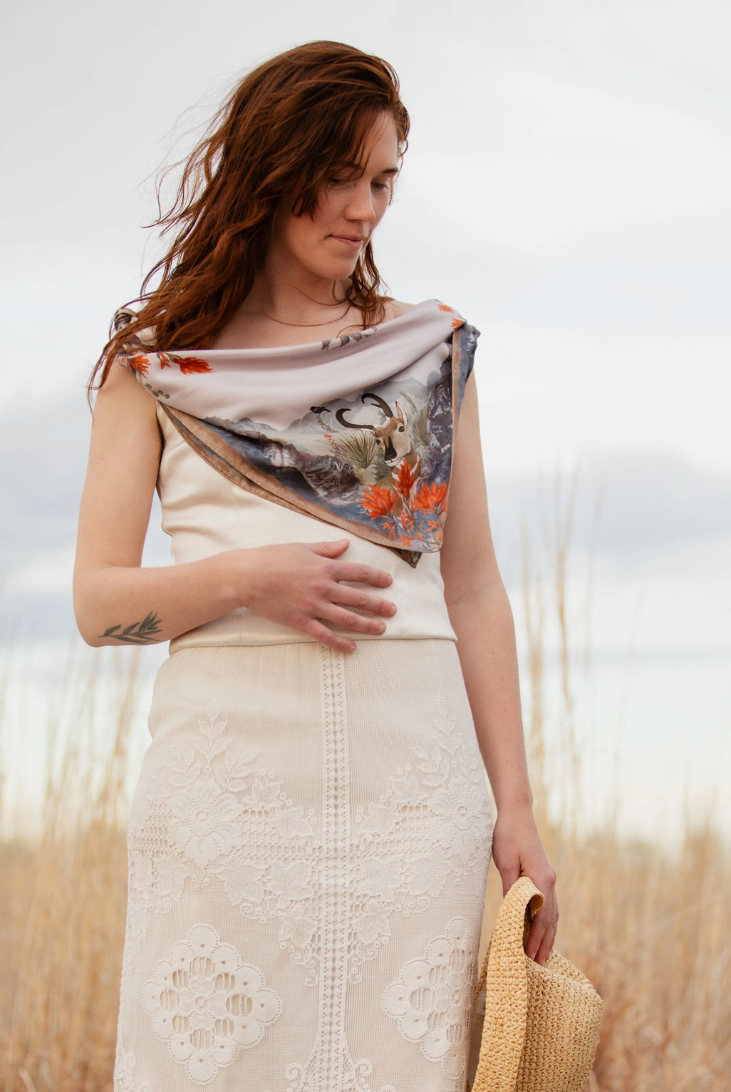 Woman with a floral scarf draped over her shoulder in a field