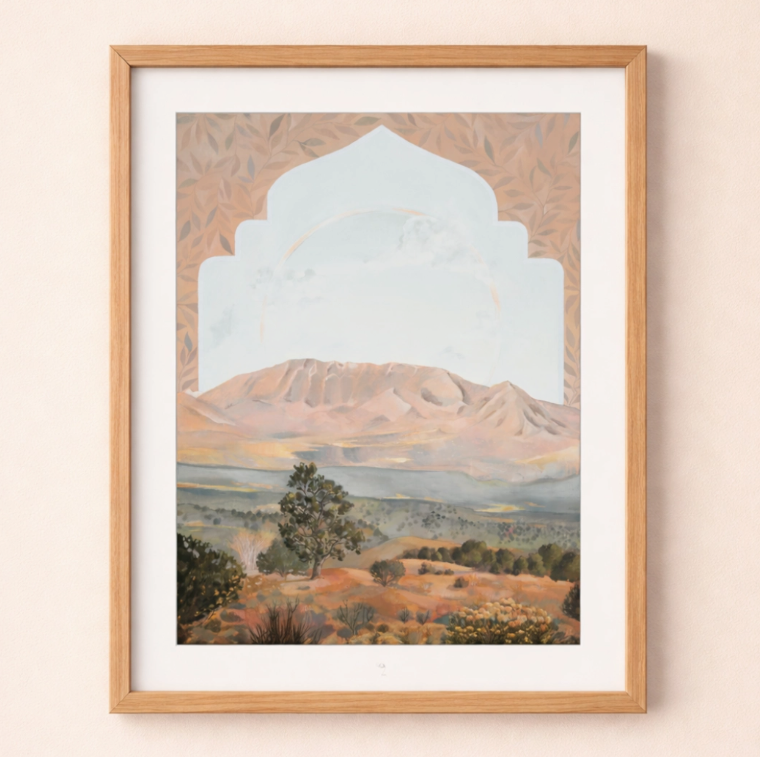 Framed artwork of a mountain landscape with an archway on a beige wall