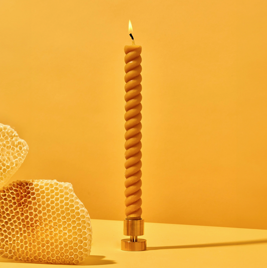 Twisted candle with honeycomb on an orange background