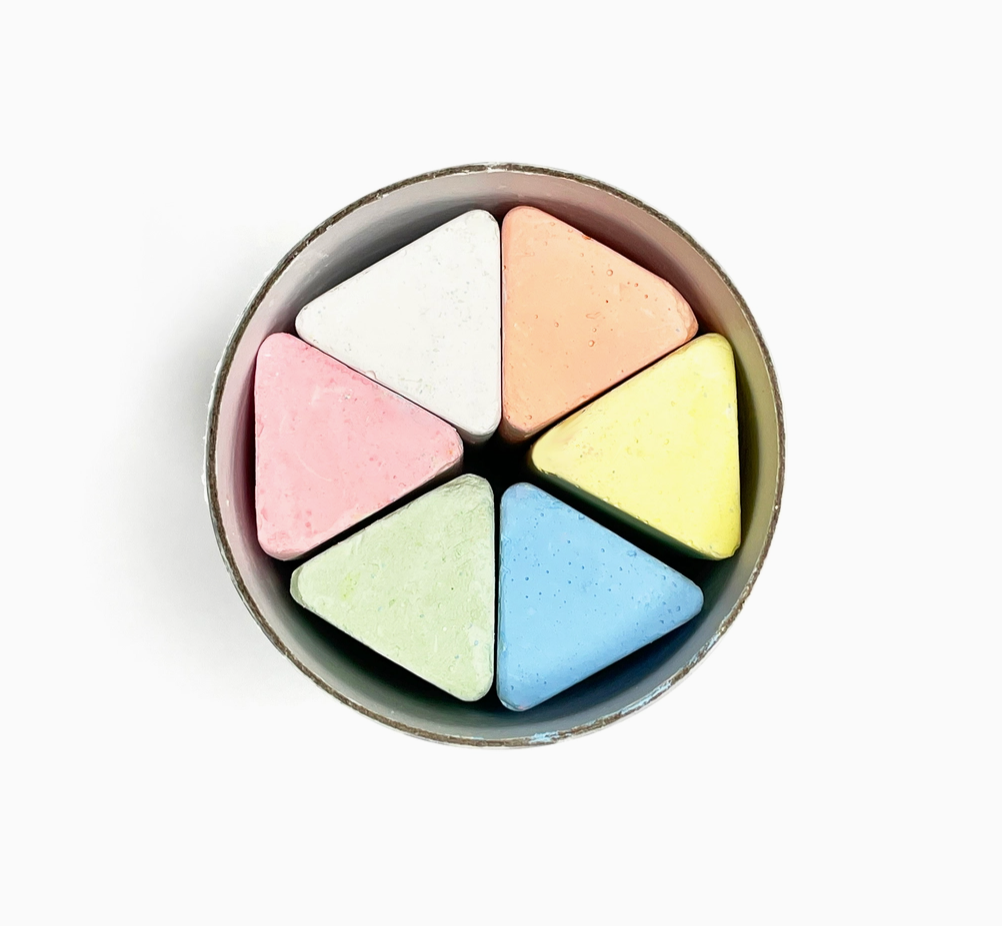 Round container with six pastel-colored watercolor crayons on a white background.