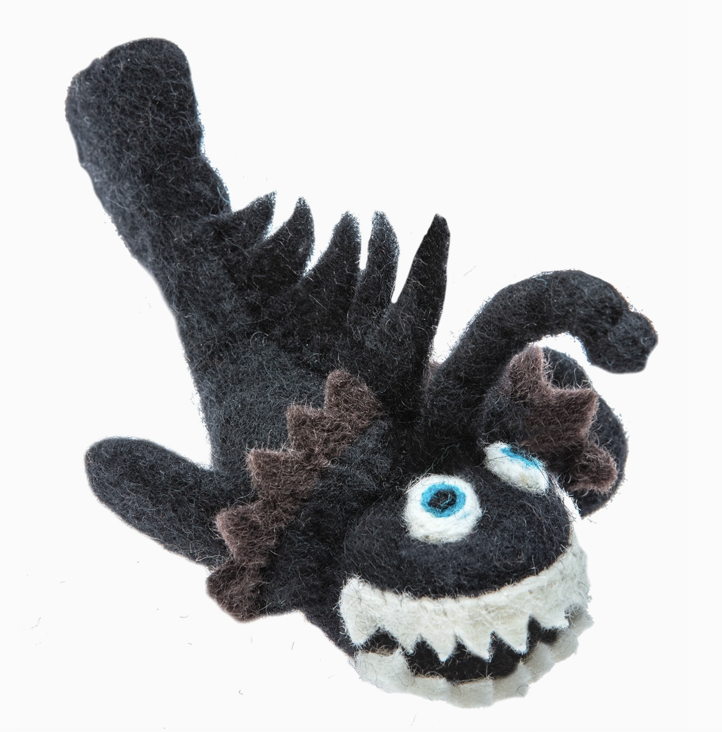 Black and white plush toy resembling a sea creature on a white background