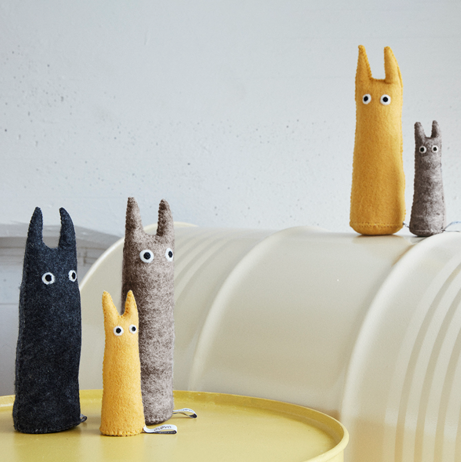 Set of plush characters on a white surface with a light gray background