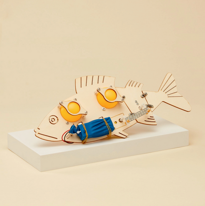 Wooden fish model with mechanical components on a beige background