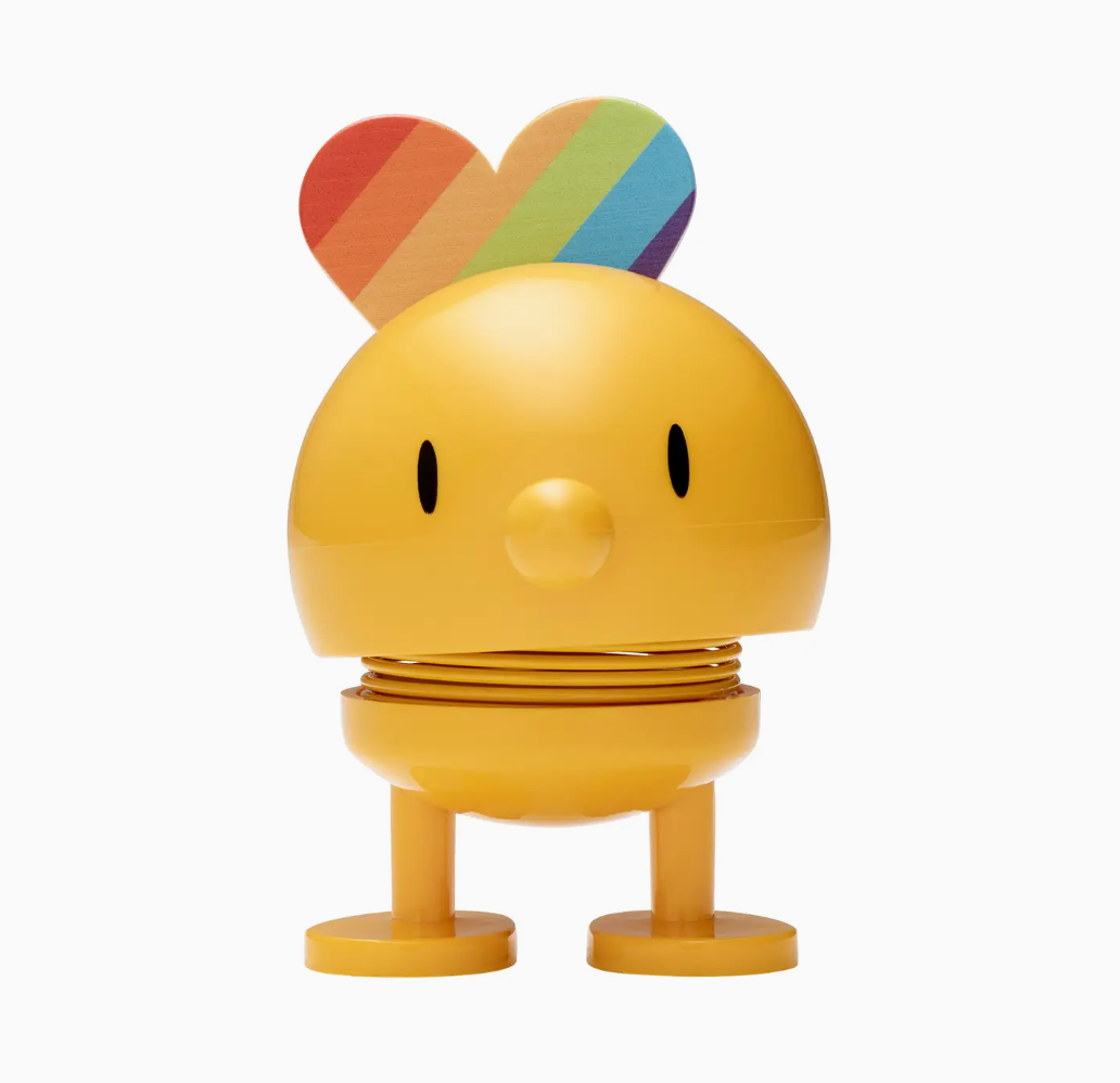 Yellow figurine with rainbow hair on a white background