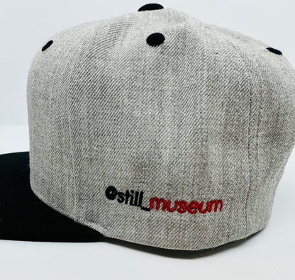 Side-view of Museum cap with @still_museum embroidered. 