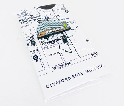 This is a soft enamel pin of the Clyfford Still Museum with a black rubber clutch.