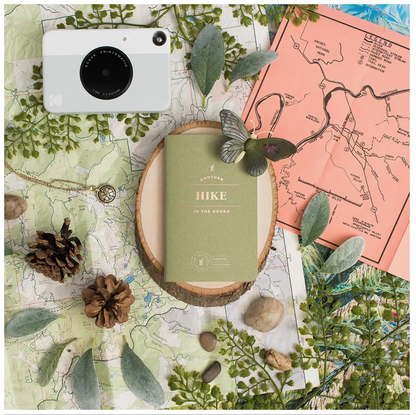 Top view photo of ‘Hike Passport’ with maps and flora  